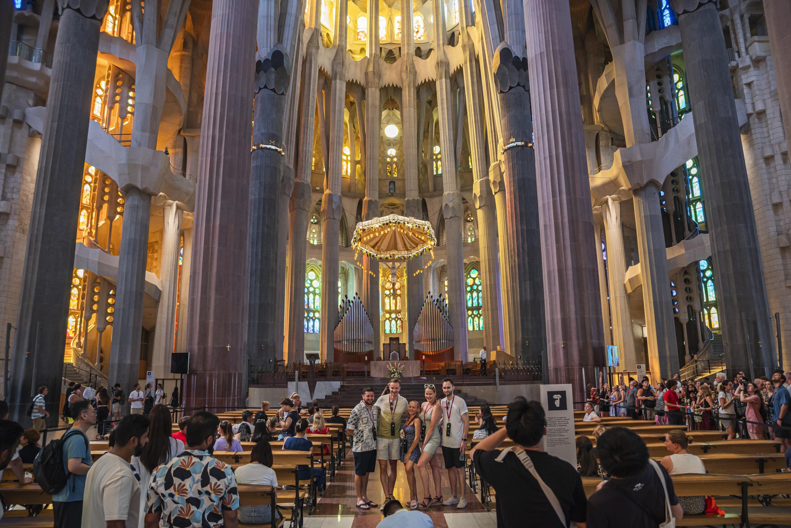 Nave central del interior de la Basílica de la Sagrada Familia de Barcelona, abarrotada de turistas.